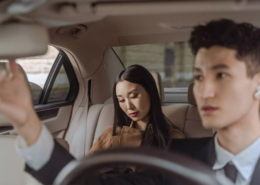 Passengers riding in the backseat of a car, representing when to consult a rideshare injury lawyer after an accident.