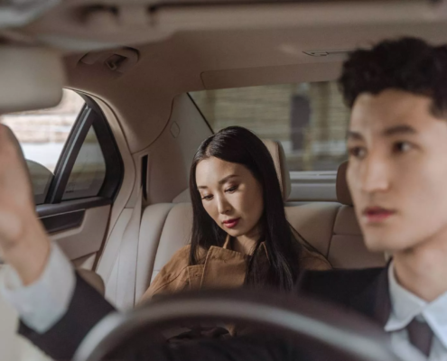 Passengers riding in the backseat of a car, representing when to consult a rideshare injury lawyer after an accident.