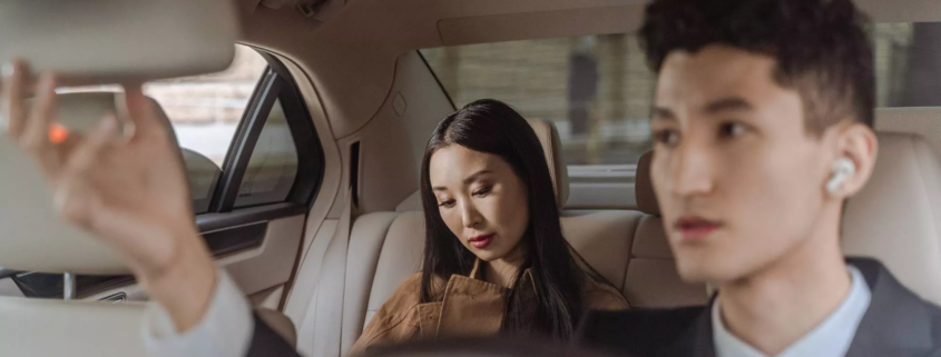 Passengers riding in the backseat of a car, representing when to consult a rideshare injury lawyer after an accident.