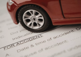 Car accident attorneys in Bend, Oregon prepare legal documents with a red toy car resting on top as a paper weight.