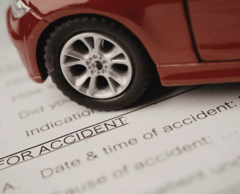 Car accident attorneys in Bend, Oregon prepare legal documents with a red toy car resting on top as a paper weight.