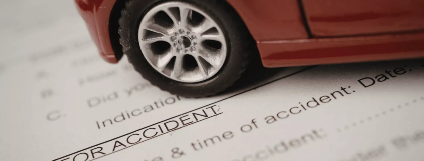 Car accident attorneys in Bend, Oregon prepare legal documents with a red toy car resting on top as a paper weight.