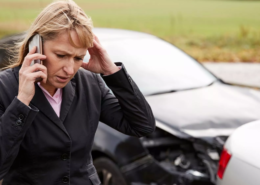 Injured driver calling for help after a car accident involving damaged vehicles