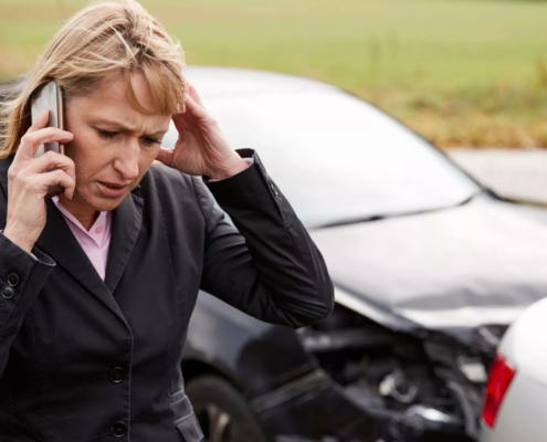 Injured driver calling for help after a car accident involving damaged vehicles