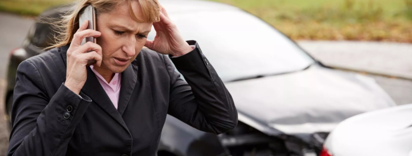 Injured driver calling for help after a car accident involving damaged vehicles